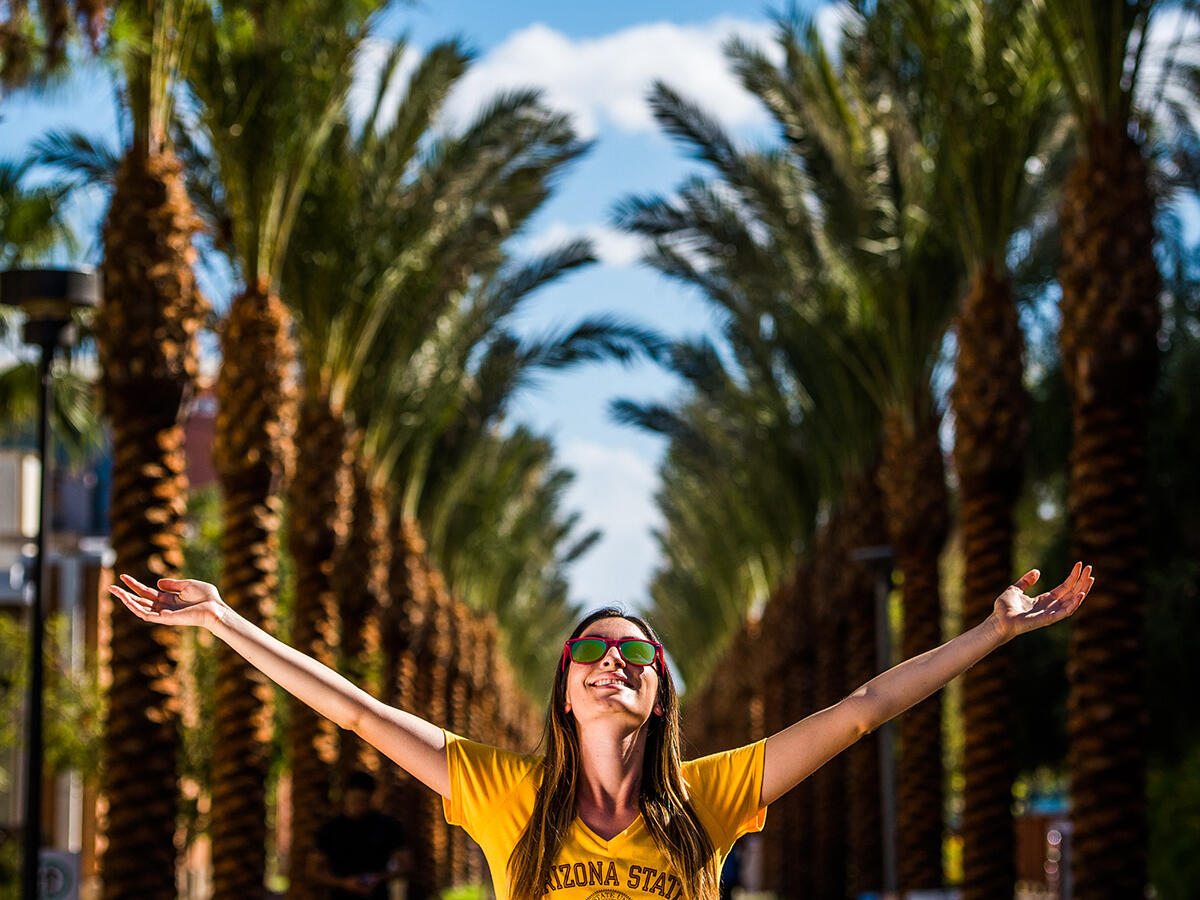Student walking with arms held high
